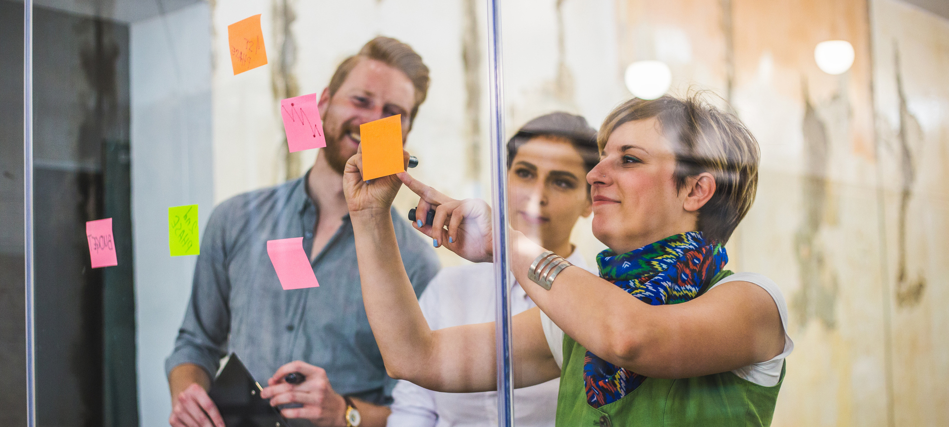 Young creative business people sticking post it notes during a meeting at an office